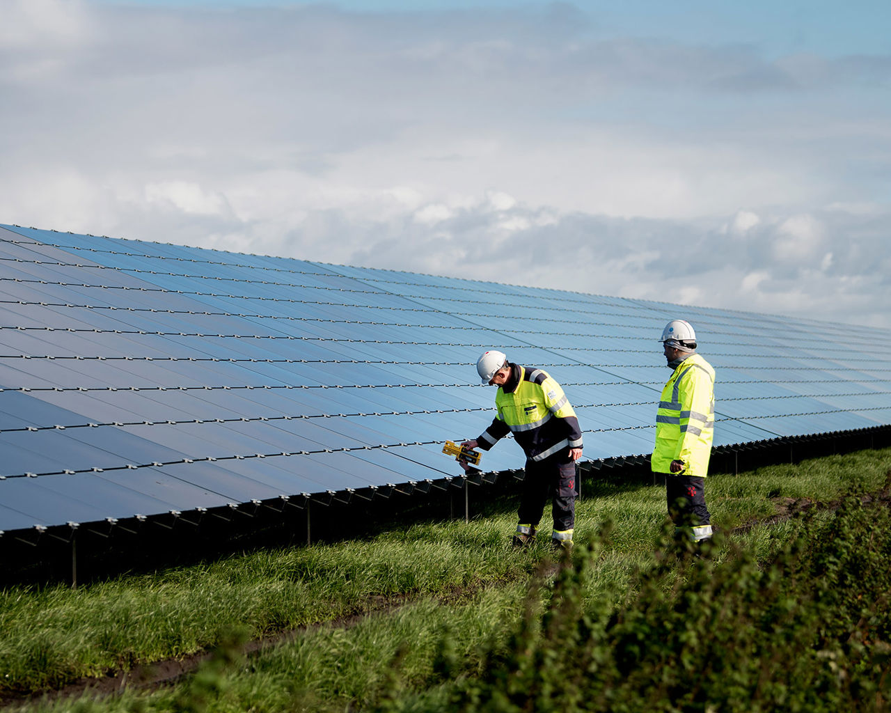 Mensen die naast zonnepanelen lopen