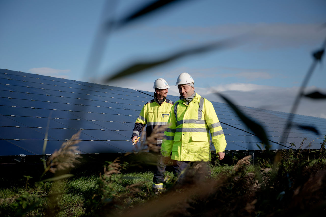 2 mannen wandelen langs zonnepanelen